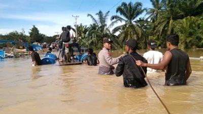 Bhabinkamtibmas Polsek Ranto Peureulak Berjibaku Bantu Evakuasi Mobil Terseret Banjir